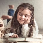 little-girl-reading-book-with-teddy-bear-floor-concept-relaxation-friendship_169016-1293